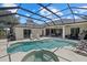 Screened-in pool and hot tub area with plenty of space for outdoor dining and relaxation at 974 Rotonda Cir, Rotonda West, FL 33947