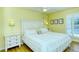 Bright bedroom with a queen-size bed, white dresser, and sliding door to balcony at 1801 Gulf N Dr # 275, Bradenton Beach, FL 34217