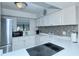 Updated kitchen featuring white cabinets, a glass cooktop, and mosaic backsplash at 1801 Gulf N Dr # 275, Bradenton Beach, FL 34217