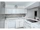 Well-equipped kitchen with white cabinets, stainless steel appliances, and mosaic backsplash at 1801 Gulf N Dr # 275, Bradenton Beach, FL 34217