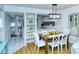 Open concept dining area with a wooden table, white chairs, and view to living room at 1801 Gulf N Dr # 275, Bradenton Beach, FL 34217