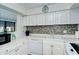 Efficient kitchen with white cabinets, stainless steel appliances and mosaic backsplash at 1801 Gulf N Dr # 275, Bradenton Beach, FL 34217