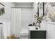 Bright bathroom featuring a shower and bathtub, vanity with marble countertop and decorative wallpaper at 807 E Genesee St, Tampa, FL 33603