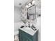 Stylish bathroom featuring vibrant wallpaper, modern lighting, and a dark green vanity with a marble countertop at 807 E Genesee St, Tampa, FL 33603