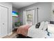 Bright bedroom featuring neutral walls, white bedding with pops of color, a cozy chair, and plenty of natural light at 807 E Genesee St, Tampa, FL 33603
