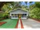 Lovely home with awnings, a yellow front door, and lush, mature landscaping at 807 E Genesee St, Tampa, FL 33603