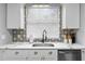 Well-lit kitchen featuring white cabinets, quartz countertops, and stylish backsplash at 807 E Genesee St, Tampa, FL 33603