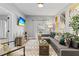 Bright living room with gray sectional sofa, decorative pillows, distinctive wall art, and natural light from a large window at 807 E Genesee St, Tampa, FL 33603