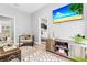 Open-concept living area features a cozy chair, sleek TV, and an adjacent dining space with natural light at 807 E Genesee St, Tampa, FL 33603