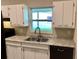 Updated kitchen with white cabinets, granite countertops, and black appliances at 6032 Merril St, North Port, FL 34287