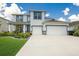 Two-story house with a three-car garage and landscaped yard at 404 158Th E St, Bradenton, FL 34212