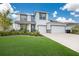 Two-story house with a three-car garage and manicured lawn at 404 158Th E St, Bradenton, FL 34212