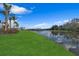 Peaceful lakefront view with green grass and palm trees at 2533 Waterfront Cir, Sarasota, FL 34240