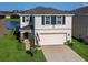 Two-story house exterior featuring a two-car garage, landscaping and an American flag at 2966 Great Abaco Way, Bradenton, FL 34208