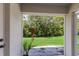 View of backyard with green grass and lush vegetation from enclosed patio at 14813 Skip Jack Loop, Lakewood Ranch, FL 34202