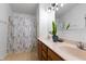 Double vanity bathroom with shower, modern light fixture, and decorative shower curtain at 14813 Skip Jack Loop, Lakewood Ranch, FL 34202