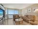 Living room with sofas, coffee table, and large window with ocean view at 1045 Gulf Of Mexico Dr # 403, Longboat Key, FL 34228