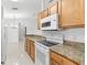 Kitchen with wood cabinets, granite countertops and a white stove at 2318 N Chamberlain Blvd, North Port, FL 34286