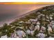 Stunning aerial view of a beachfront home at sunset at 102 75Th St, Holmes Beach, FL 34217