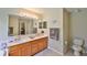 Well-lit bathroom with double sinks, granite countertops, and a large mirror at 11622 Summit Rock Ct, Parrish, FL 34219