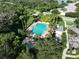 Aerial view of a large community pool with lush landscaping, seating areas, and a hot tub at 11622 Summit Rock Ct, Parrish, FL 34219