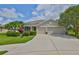 Charming single-story home featuring a manicured lawn, mature trees, and a spacious three-car garage at 11622 Summit Rock Ct, Parrish, FL 34219