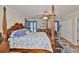 Relaxing main bedroom with a four-poster bed, dresser, plush chair, and natural light at 11622 Summit Rock Ct, Parrish, FL 34219
