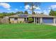 Ranch-style home with solar panels, blue garage door, and a spacious lawn at 3220 Valencia Rd, Venice, FL 34293