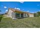 Home's backyard with a screened-in lanai and terracotta roof at 4223 Murfield E Dr, Bradenton, FL 34203