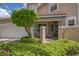 Partial view of a tan townhome showcasing a gated entry and lush landscaping at 1711 Starling Dr # 1711, Sarasota, FL 34231