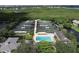Aerial view of community tennis courts, pool, and lush landscaping at 1711 Starling Dr # 1711, Sarasota, FL 34231