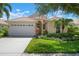 Single-story house featuring a two-car garage and well-maintained landscaping at 4140 Reflections Pkwy, Sarasota, FL 34233