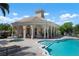 Community pool with a clubhouse featuring a spa and seating area at 4140 Reflections Pkwy, Sarasota, FL 34233