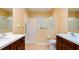 Bathroom featuring double vanity sinks, walk-in shower with glass partition and accessibility features at 4830 Maymont Park Cir, Bradenton, FL 34203