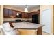 Well-equipped kitchen boasts stainless steel appliances, solid countertops, tile backsplash, and dark wood cabinets at 4830 Maymont Park Cir, Bradenton, FL 34203
