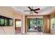 Spacious living room featuring tile floors, ceiling fan, and sliding glass doors to outdoor living at 4830 Maymont Park Cir, Bradenton, FL 34203