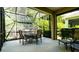 Comfortable screened patio with an outdoor dining table, chairs, and a lush green view at 4830 Maymont Park Cir, Bradenton, FL 34203