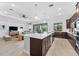 Large kitchen with island, dark wood cabinets, and stainless steel appliances at 25081 Spartina Dr, Venice, FL 34293