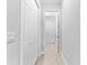 Long hallway with white doors and tiled floor at 25081 Spartina Dr, Venice, FL 34293
