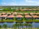 Aerial view of luxury homes with pools, situated along a canal and golf course at 25081 Spartina Dr, Venice, FL 34293