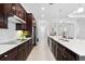 Modern kitchen with dark cabinetry, quartz countertops, and stainless steel appliances at 25081 Spartina Dr, Venice, FL 34293