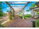 Elegant walkway with pergola, lush landscaping, and seating areas at 25081 Spartina Dr, Venice, FL 34293