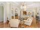 Open living room featuring hardwood floors, built-in shelving, and a cozy seating area at 811 Riviera Dunes Way, Palmetto, FL 34221