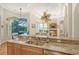 Large kitchen with granite countertops, breakfast bar, and views of the backyard oasis at 811 Riviera Dunes Way, Palmetto, FL 34221