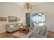 Living room with hardwood floors, sofas, coffee table, and pool view at 811 Riviera Dunes Way, Palmetto, FL 34221