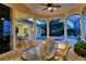 Covered patio with dining table and chairs, overlooking pool and water at 811 Riviera Dunes Way, Palmetto, FL 34221