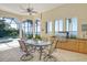 Outdoor kitchen and dining area with a built-in grill and pool view at 811 Riviera Dunes Way, Palmetto, FL 34221