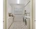 Bright laundry room featuring built-in cabinets, a window with shutters, and a stylish rug at 811 Riviera Dunes Way, Palmetto, FL 34221