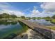 Wooden bridge over calm water, reflecting the sky, leads across a scenic golf course at 5145 96Th E St, Bradenton, FL 34211