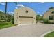 Attached garage with light-beige door and decorative arched entry at 360 N Point Rd, Osprey, FL 34229
